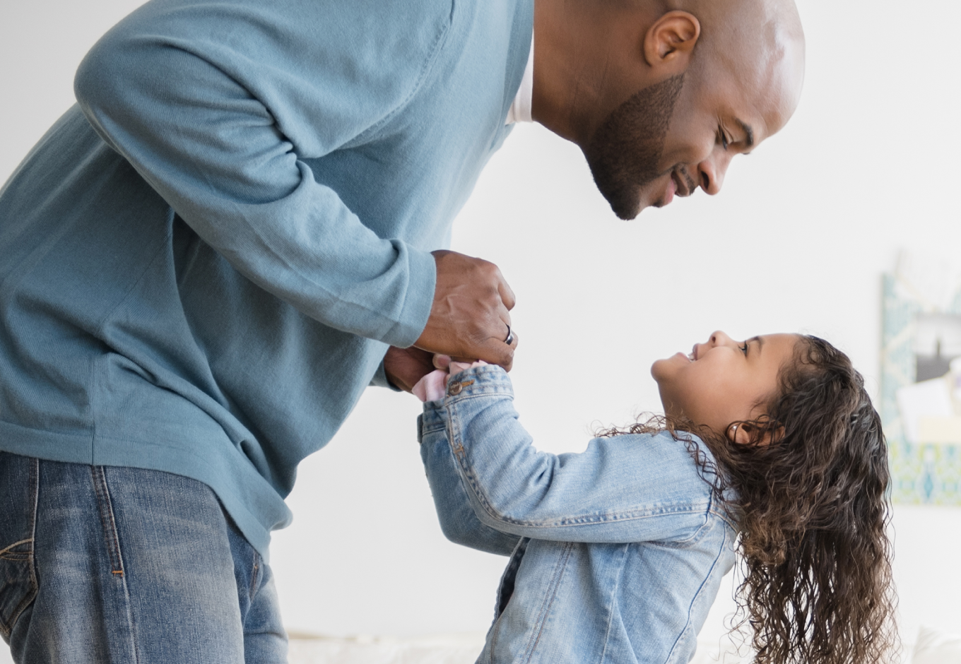Father and daughter smiling at each other, showcasing a loving bond.
